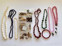 Full view of all necklaces, bracelets, charms and jewelry making supplies arranged on flat surface