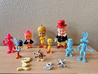 Full view of all 12 Looney Tunes plastic figurines, showing color variety and character poses.