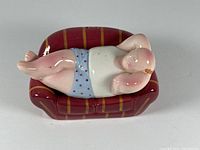 Top-down angle of the reclining man salt and pepper shaker showing the figure's red hair, blue polka dot shorts, and red plaid sofa.