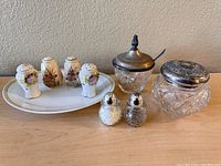 Entire lot shown with salt and pepper shakers on tray, two glass shakers, and two glass condiment containers with metal lids