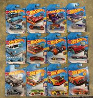 Photo showing 12 Hot Wheels toy cars in original blue blister packages, including the Rocket Oil Special and Surfin' School Bus Special models.