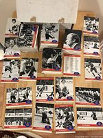 Overall view of the collection of black and white 1972 Summit Series hockey cards, showing multiple stacks and loose cards on a table.