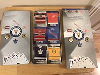 Top-down view of the collectible metal tin and boxed NHL playing cards showing the tin opened and six sealed decks inside.
