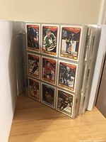 View of several hockey cards in plastic sleeves within binder, showing uniform design and collection size.