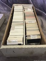 Top view of a large box filled with hockey cards divided into two sections. The left section is labeled 'Checklists' and the right section is divided further into 'Gold/Emerald Cards' and other types of cards.