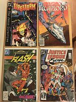 Top view of the four DC Comics comic books laid out flat showing cover artwork and titles Firestorm #7, The Warlord, The Flash, and Justice League Europe.