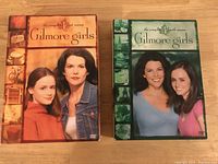 Front view of Gilmore Girls Complete Season 1 and Season 4 DVD box sets showing artwork and main cast.