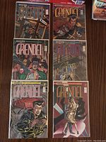 Photo showing all six Grendel comics arranged on a wooden surface, all in protective plastic bags with backing boards.