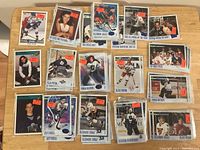 Photo showing a collection of hockey cards arranged on a wooden surface, cards individually sleeved with orange sale price stickers, featuring various players such as Jeff O'Neill and Alexandre Daigle.