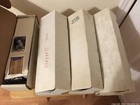 Four large boxes of baseball cards on a wooden table, one labeled 1993 Donruss.