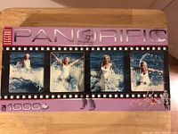 Front view of the puzzle box showing the full panoramic photo of Marilyn Monroe in four frames enjoying ocean waves, with branding and piece count visible.