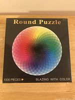 Photo of the sealed Round Puzzle box showing title, 1000 pieces, and colorful circular artwork.