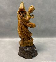 Full side view of carved soapstone statue of Guanyin lady with flowing robes and detailed hair, standing on carved base.