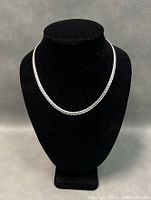 Front view of sterling silver 17.5-inch chain necklace displayed on black stand, showing full length and style.