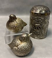 Front angle showing tea caddy with embossed elephants and the two bird-shaped salt and pepper shakers with detailed feather textures.