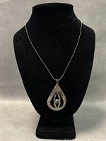 Front view of necklace on black bust displaying pendant and chain length.