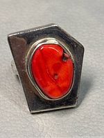 Close-up front view of the geometrical 925 sterling silver ring with red coral stone showing natural inclusions and polished finish.