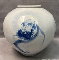 Front view of the vase showing the hand-painted face of a bearded man in blue on white porcelain.
