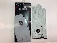 Photo of packaging and new Callaway Opti Flex leather palm golf glove with size and price tag visible.