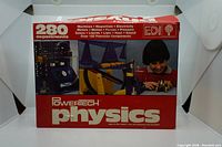 Original box front showing product name Powertech Physics with a child conducting an experiment and various instruments visible.