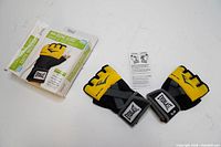 Pair of yellow and black Everlast Shadow Boxing Gloves with elastic mesh pockets and adjustable wrist straps, laid flat with hang tag.