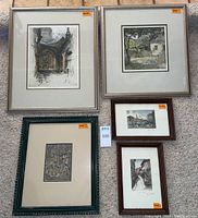 Six framed art pieces arranged on floor showing variety of sizes and frames.