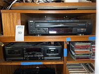 RCA 5 disc CD player front view, black unit with buttons and disc slot.