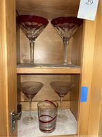 Side angle of the two red Waterford martini glasses showing the red color and cut crystal detail.