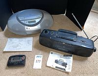 Sony CFD-S350 silver portable CD player with digital display and speakers captured from top and rear angles, manual and remote shown; GE 3-5620 black AM/FM radio cassette player with manuals shown; AIWA TX456 cassette player shown.