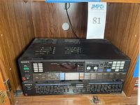 Sony STR-AV460 FM Stereo/AM Receiver and SEQ-210 Graphic Equalizer stacked inside a wooden cabinet.