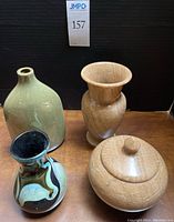 Front view of four-piece set including art glass vase, ceramic vase, agate urn with lid, and stone-like vase pot