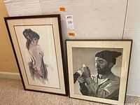 Framed black pastel portrait of a woman and framed black and white photo of a man side by side.