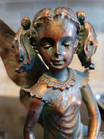 Close-up front view of the angel's face and upper body showcasing detailed facial expression, hair pigtails, and dress texture.