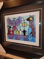 Framed fine art print showing colorful Thunderbird Rising design with signature and title visible.