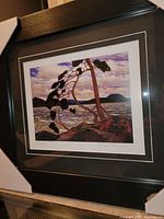 Photo of the framed fine art print showing the pine tree, water, and hills with the signature and title visible.
