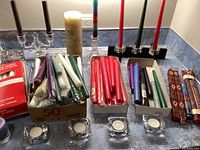 Overview of candles and candle holders including different colored taper candles, pillar candles, decorative holders, and glass holders