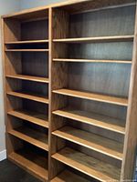 Front view of double wide oak bookcase with six adjustable shelves on each side.