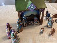 Painted wooden nativity set with stable and various figures arranged on table