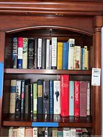 Books on two shelves in a wooden bookcase, showing titles and condition of books including presidential biographies and historical works.