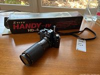 Stitz Handy-IV HD-4 tripod with original box on wooden surface, tripod extended horizontally