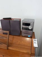 Full view of Hi-Fi system including main unit, two speakers, and remote on wooden surface.