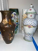 Four decorative vases displayed together showing different shapes, colors, and floral designs.