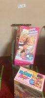 Boxed Baby Alive doll and baby stroller in background