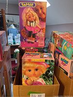 Group photo of three retro dolls in original boxes including Tapsie, Bizzie Lizzie, and Baby Face Laura.