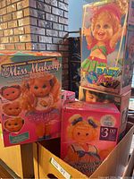 Three sealed doll boxes displayed together on a table: Lil’ Petite Miss Makeup, Baby Face So Funny Natalie, and small pink Wanna Wanta Petite doll.