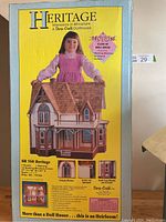 Front of the original box showing a young girl holding the miniature Victorian Gothic style dollhouse. The packaging displays the product title, features, and images of the dollhouse.