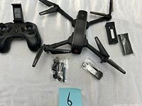 Folded Ascend 2500 drone with remote controller and accessories laid out on a white surface.