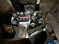 Overview of wheel caps, mirror extenders, and gauge kit laid out on table.