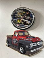 Photo of both Jimmie Johnson NASCAR clock and Ford truck tin sign together.