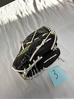 Black Mizuno left handed baseball glove showing front and interior details, white lacing, neon yellow logo